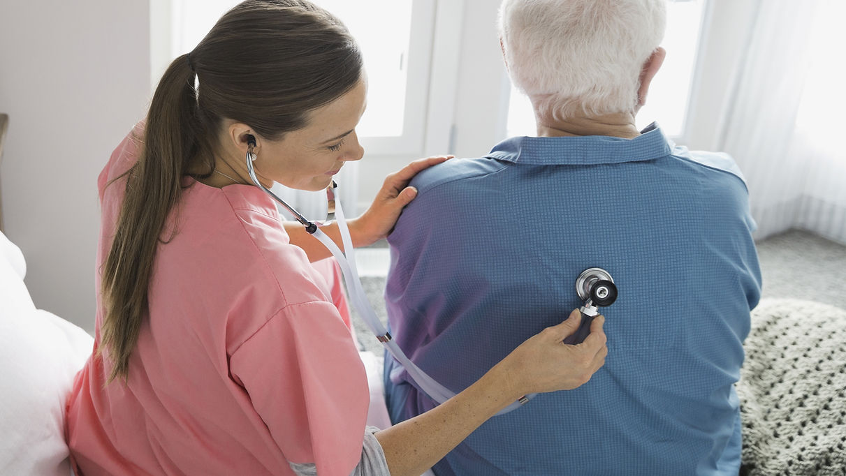 A Linil nurse checking a senior patient's vitals at home