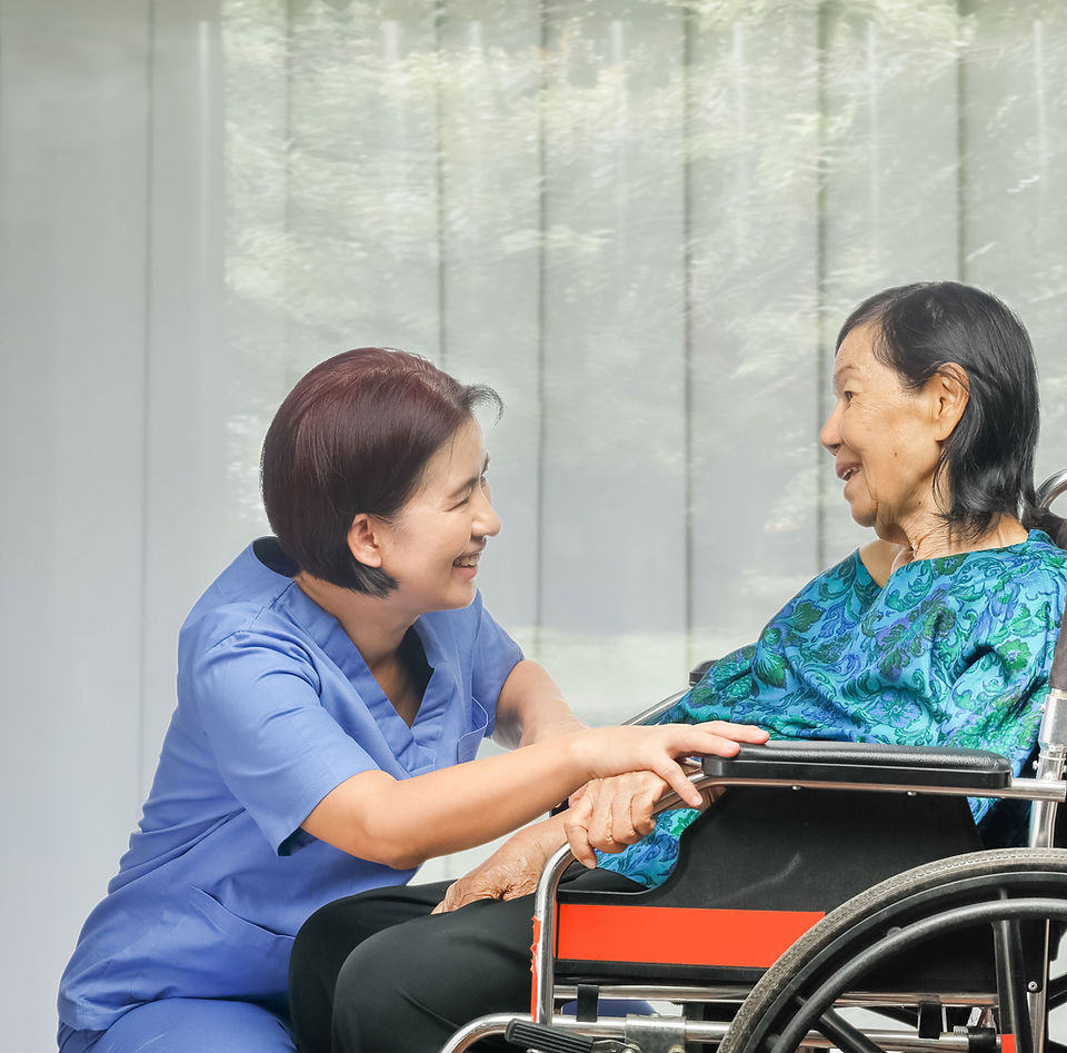 A Linil aide assisting a senior in a wheelchair